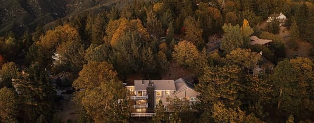 Quiet Hill Country evening with a vacation rental glowing warmly under oak trees